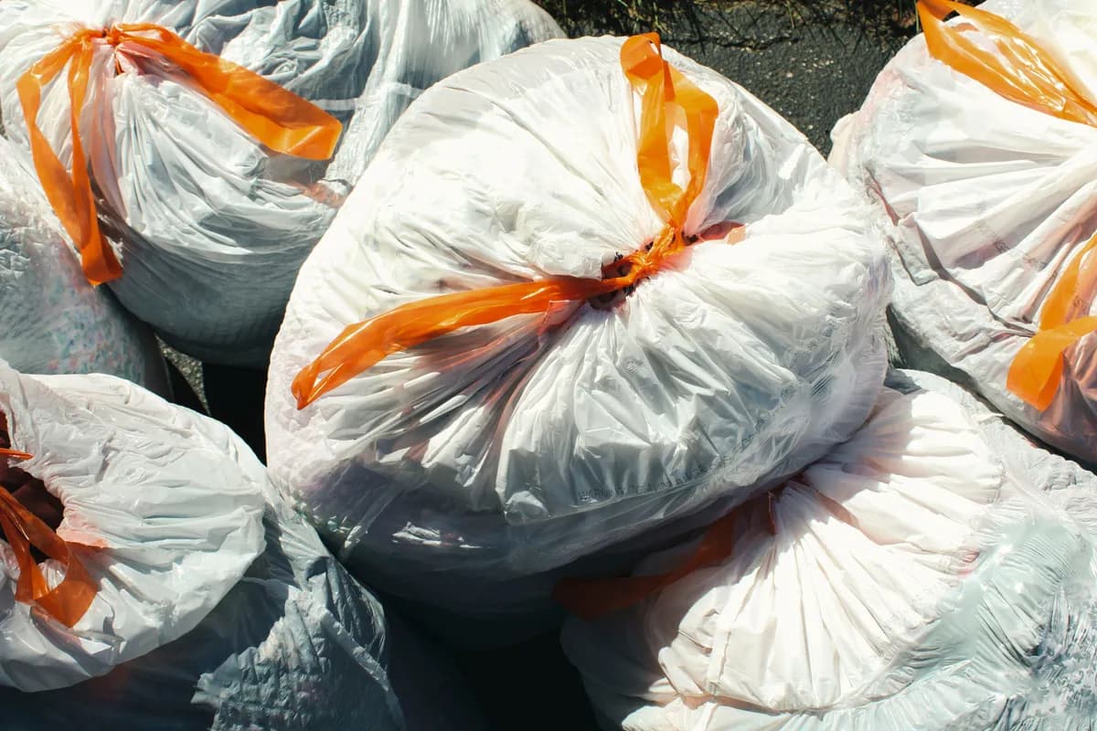 Household garbage bags tied and gathered together, ready for collection.